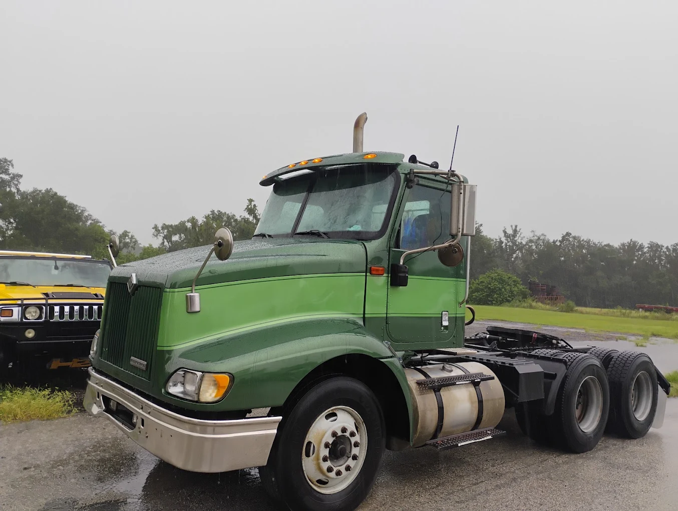 Green International semi truck with dual rear axles parked at outdoor lot
