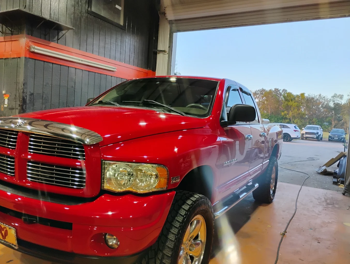 Red Dodge Ram pickup truck being washed in an auto detailing facility