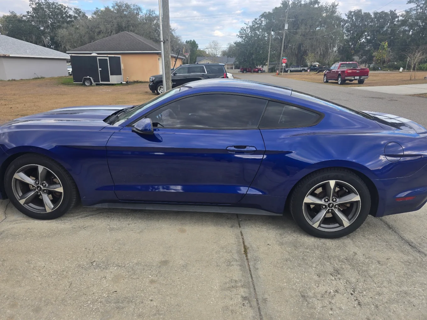 Blue Dodge Charger coupe parked on street in residential neighborhood