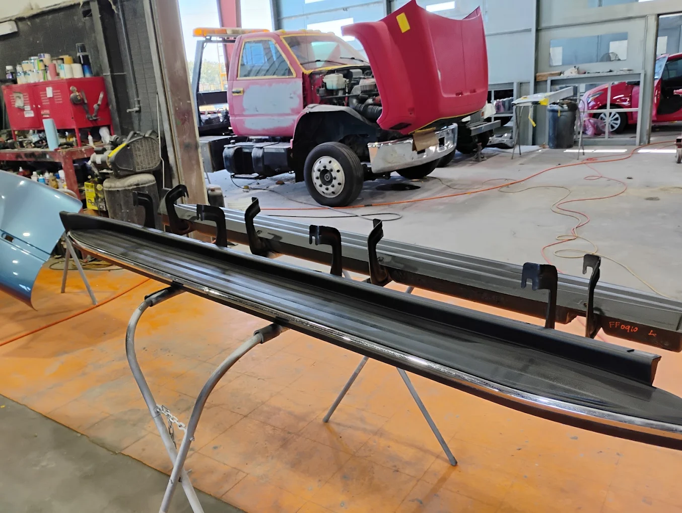 Vehicle parts and truck undergoing repairs in industrial garage workshop