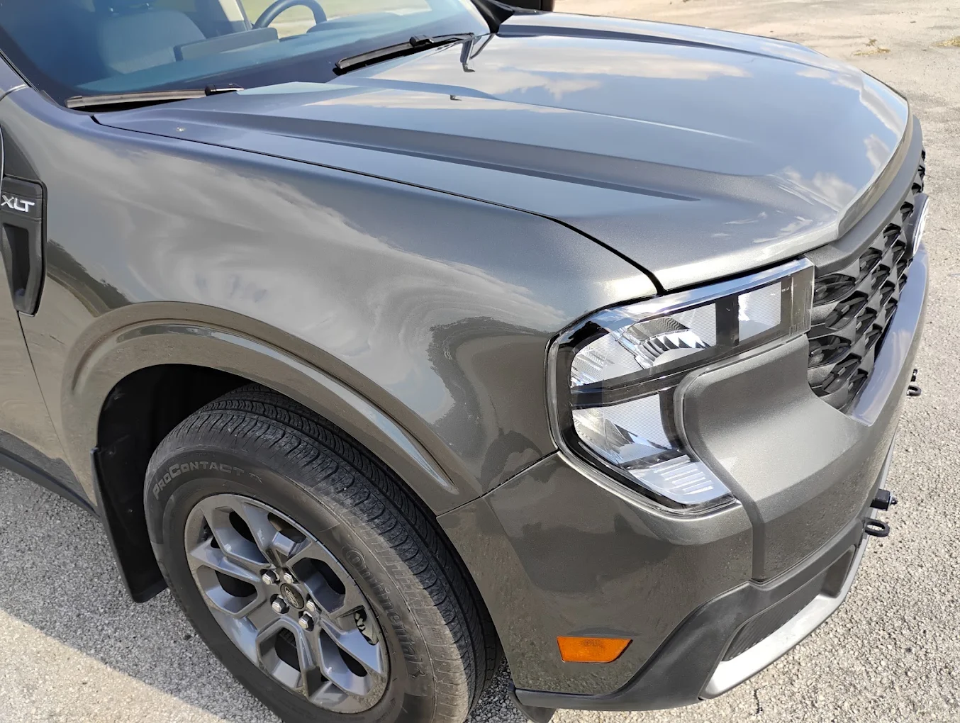 Silver pickup truck front quarter view with hood open in daylight